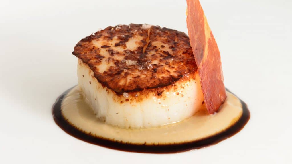 Vieira a la plancha con topinambur, salsa de cebolla escalibada y chip ibérico
