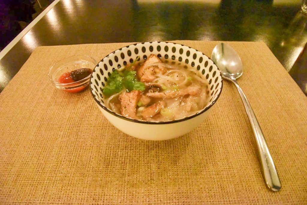 Vegetatian Phở: cooked for several hours, topped with tofu, onion, coriander and spring onion. Hoisin and chilli sauce accompany the dish.